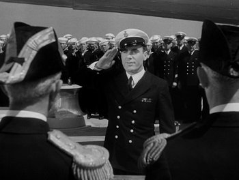 Movie still from “Here Comes the Navy” (1934), directed by Lloyd Bacon – A man in a uniform saluting in front of a group of people; Medium shot, Low angle