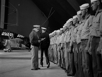 Movie still from “Here Comes the Navy” (1934), directed by Lloyd Bacon – A group of men standing next to each other in uniform; Wide shot, Low angle