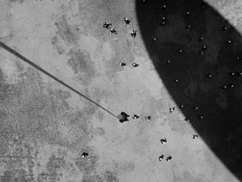 Movie still from “Here Comes the Navy” (1934), directed by Lloyd Bacon – An aerial view of a group of people standing on the ground; Extreme Wide shot, Overhead angle