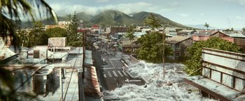 Movie still from “Hereafter” (2010), directed by Clint Eastwood – A city street with buildings and a street sign on the side of the street; Extreme Wide shot, High angle