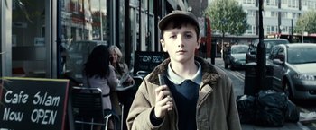 Movie still from “Hereafter” (2010), directed by Clint Eastwood – A young boy holding a cell phone in his hand; Close Up shot, Low angle