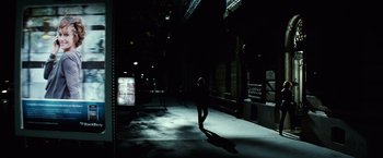 Movie still from “Hereafter” (2010), directed by Clint Eastwood – A person walking in the dark on a sidewalk; Wide shot, Low angle