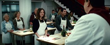 Movie still from “Hereafter” (2010), directed by Clint Eastwood – A group of people standing around a table with wine glasses; Medium shot, Over the shoulder angle