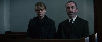 Movie still from “Hereafter” (2010), directed by Clint Eastwood – A man and a woman sitting next to each other in a courtroom; Medium shot, Low angle