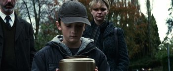 Movie still from “Hereafter” (2010), directed by Clint Eastwood – A boy and a woman looking at a container; Close Up shot, Over the shoulder angle