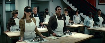Movie still from “Hereafter” (2010), directed by Clint Eastwood – A group of people standing in a kitchen preparing food; Medium shot, High angle