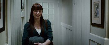 Movie still from “Hereafter” (2010), directed by Clint Eastwood – A woman with long red hair sitting in front of a white door; Medium shot, Over the shoulder angle