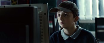 Movie still from “Hereafter” (2010), directed by Clint Eastwood – A young boy wearing a hat looking at a computer screen; Close Up shot, Over the shoulder angle
