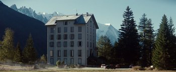 Movie still from “Hereafter” (2010), directed by Clint Eastwood – A large white building sitting in front of a mountain range; Extreme Wide shot, Low angle