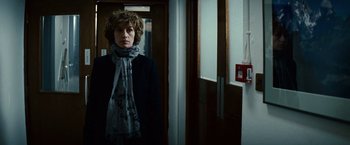 Movie still from “Hereafter” (2010), directed by Clint Eastwood – A woman standing in front of a door wearing a scarf; Medium shot, Low angle