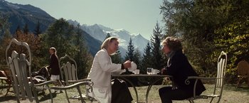 Movie still from “Hereafter” (2010), directed by Clint Eastwood – Two people sitting at a table with mountains in the background; Wide shot, Over the shoulder angle