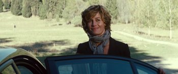 Movie still from “Hereafter” (2010), directed by Clint Eastwood – A woman in a black jacket standing next to a blue car; Medium shot, Over the shoulder angle