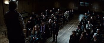Movie still from “Hereafter” (2010), directed by Clint Eastwood – A group of people sitting in rows in a room; Wide shot, High angle