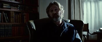 Movie still from “Hereafter” (2010), directed by Clint Eastwood – A man sitting in a chair with a beard; Close Up shot, Over the shoulder angle