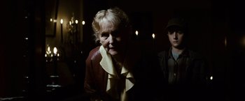 Movie still from “Hereafter” (2010), directed by Clint Eastwood – An older woman in a brown jacket standing next to a young man; Medium shot, Over the shoulder angle