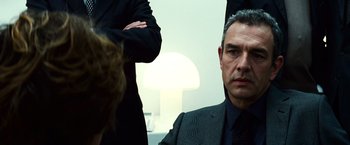 Movie still from “Hereafter” (2010), directed by Clint Eastwood – A man in a suit and tie sitting in front of a lamp; Close Up shot, Over the shoulder angle
