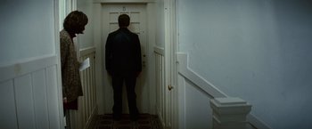 Movie still from “Hereafter” (2010), directed by Clint Eastwood – A man standing in front of an open door; Wide shot, Low angle