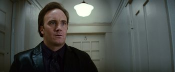 Movie still from “Hereafter” (2010), directed by Clint Eastwood – A person wearing a suit in a room; Close Up shot, Low angle