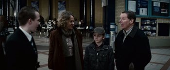 Movie still from “Hereafter” (2010), directed by Clint Eastwood – A woman standing next to a young boy in a crowd; Medium shot, Over the shoulder angle