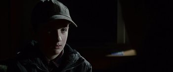 Movie still from “Hereafter” (2010), directed by Clint Eastwood – A young boy wearing a hat and jacket; Close Up shot, Over the shoulder angle