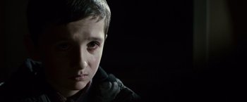 Movie still from “Hereafter” (2010), directed by Clint Eastwood – A young boy with tears in his eyes; Close Up shot, Over the shoulder angle