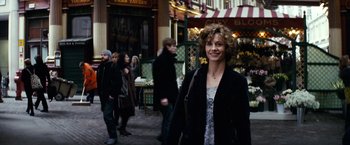 Movie still from “Hereafter” (2010), directed by Clint Eastwood – A woman is walking down the street in a city; Medium shot, Over the shoulder angle