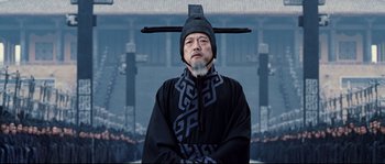 Movie still from “Hero” (2002), directed by Yimou Zhang – A man wearing a black robe and a black hat; Medium shot, Low angle