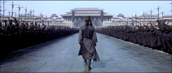 Movie still from “Hero” (2002), directed by Yimou Zhang – A man walking down a street in front of a crowd of people; Wide shot, Low angle