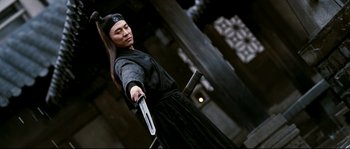 Movie still from “Hero” (2002), directed by Yimou Zhang – A man holding a sword in his hand; Medium shot, Over the shoulder angle