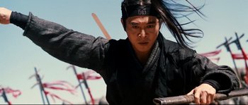 Movie still from “Hero” (2002), directed by Yimou Zhang – A man with long black hair wearing a black hat; Close Up shot, Low angle