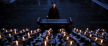 Movie still from “Hero” (2002), directed by Yimou Zhang – A man sitting in front of a group of lit candles; Wide shot, High angle