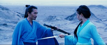 Movie still from “Hero” (2002), directed by Yimou Zhang – A man and a woman are holding swords in the mountains; Medium shot, Over the shoulder angle