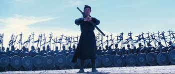 Movie still from “Hero” (2002), directed by Yimou Zhang – A man holding a sword in front of a group of soldiers; Wide shot, Low angle
