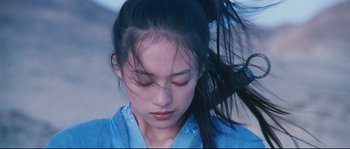 Movie still from “Hero” (2002), directed by Yimou Zhang – A young woman in a blue shirt with her hair blowing in the wind; Close Up shot, Low angle