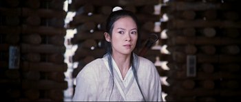 Movie still from “Hero” (2002), directed by Yimou Zhang – A woman in a white robe with a pipe in her mouth; Close Up shot, Low angle
