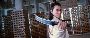 Movie still from “Hero” (2002), directed by Yimou Zhang – A man holding a sword in a warehouse; Medium shot, Low angle