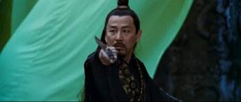 Movie still from “Hero” (2002), directed by Yimou Zhang – A man with a long black hair and a beard holding a knife in his hand; Close Up shot, Over the shoulder angle