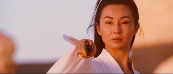 Movie still from “Hero” (2002), directed by Yimou Zhang – A woman in a white shirt is holding a knife; Close Up shot, Low angle