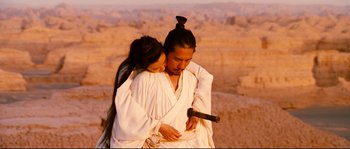 Movie still from “Hero” (2002), directed by Yimou Zhang – A man and a woman dressed in white holding a sword; Medium shot, Over the shoulder angle