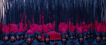 Movie still from “Hero” (2002), directed by Yimou Zhang – A group of men in black and red uniforms holding a red umbrella; Extreme Wide shot, High angle