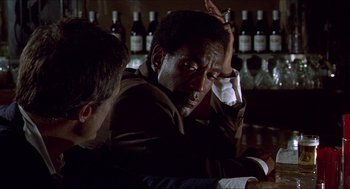 Movie still from “Hickey & Boggs” (1972), directed by Robert Culp – A man sitting at a table with another man; Medium shot, Over the shoulder angle
