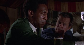 Movie still from “Hickey & Boggs” (1972), directed by Robert Culp – Two men sitting at a table in front of a glass of beer; Close Up shot, Low angle