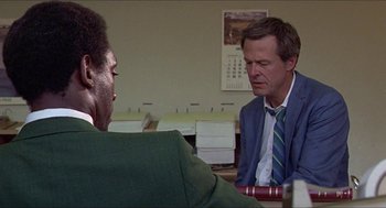 Movie still from “Hickey & Boggs” (1972), directed by Robert Culp – A man in a suit and tie talking to another man in a suit and tie; Close Up shot, Over the shoulder angle