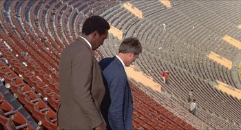 Movie still from “Hickey & Boggs” (1972), directed by Robert Culp – Two men in suits are standing in an amphitheater; Extreme Wide shot, High angle