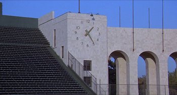 Movie still from “Hickey & Boggs” (1972), directed by Robert Culp – A clock on the side of a white building; Extreme Wide shot, Low angle