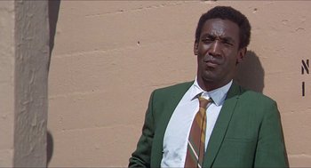 Movie still from “Hickey & Boggs” (1972), directed by Robert Culp – A man in a green jacket and a yellow tie; Close Up shot, Low angle