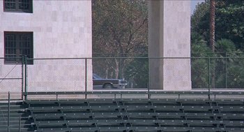 Movie still from “Hickey & Boggs” (1972), directed by Robert Culp – A car is parked in a parking lot next to a fence; Extreme Wide shot, High angle