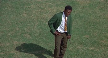 Movie still from “Hickey & Boggs” (1972), directed by Robert Culp – A man in a green jacket and brown pants standing on a field; Medium shot, Low angle