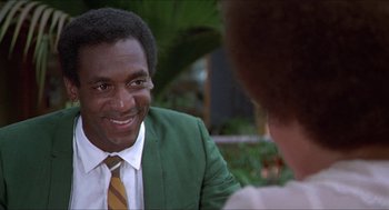 Movie still from “Hickey & Boggs” (1972), directed by Robert Culp – A man wearing a green jacket and a yellow and white striped tie; Close Up shot, Over the shoulder angle