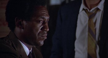Movie still from “Hickey & Boggs” (1972), directed by Robert Culp – A person wearing a suit and tie; Close Up shot, Low angle